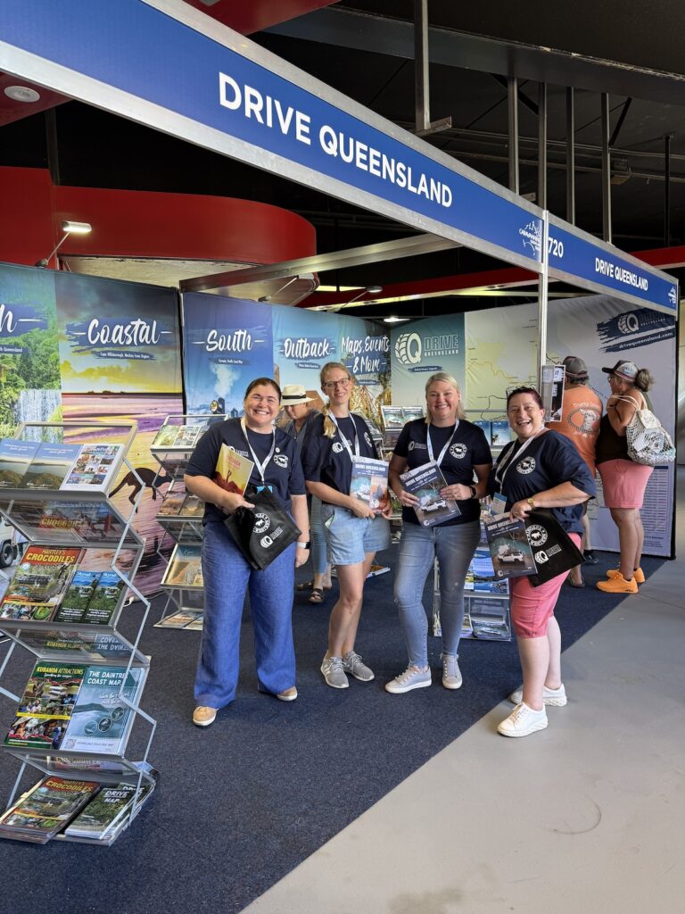 Four women stand in front of a 