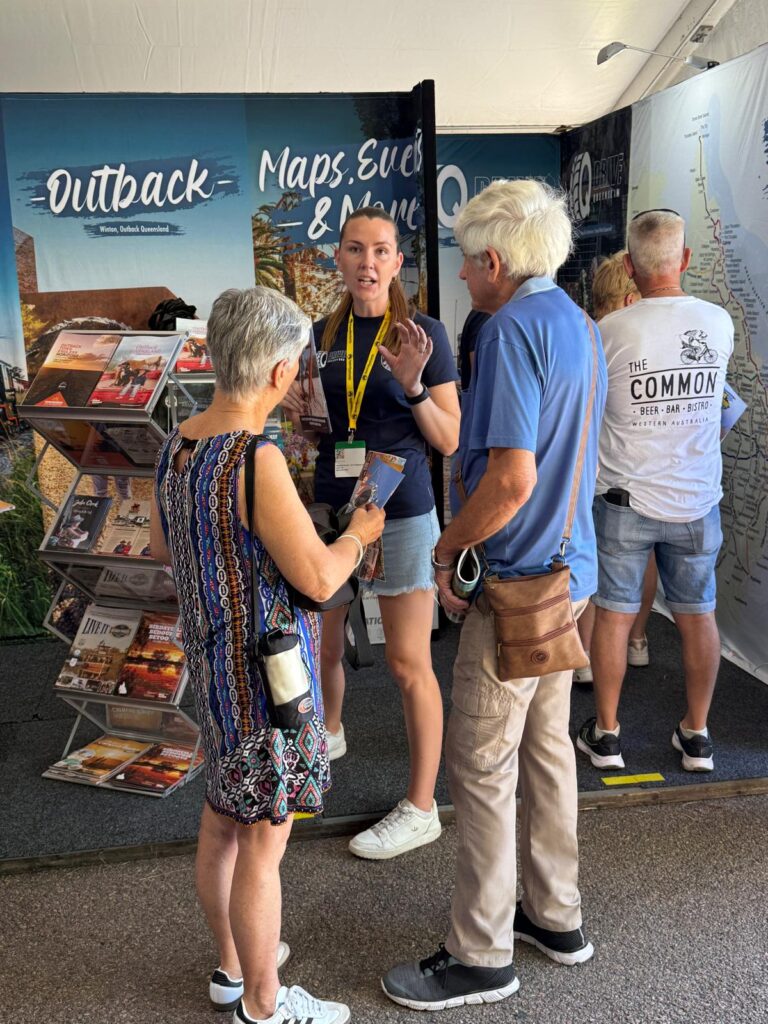 A young woman stands at an informational booth labeled 