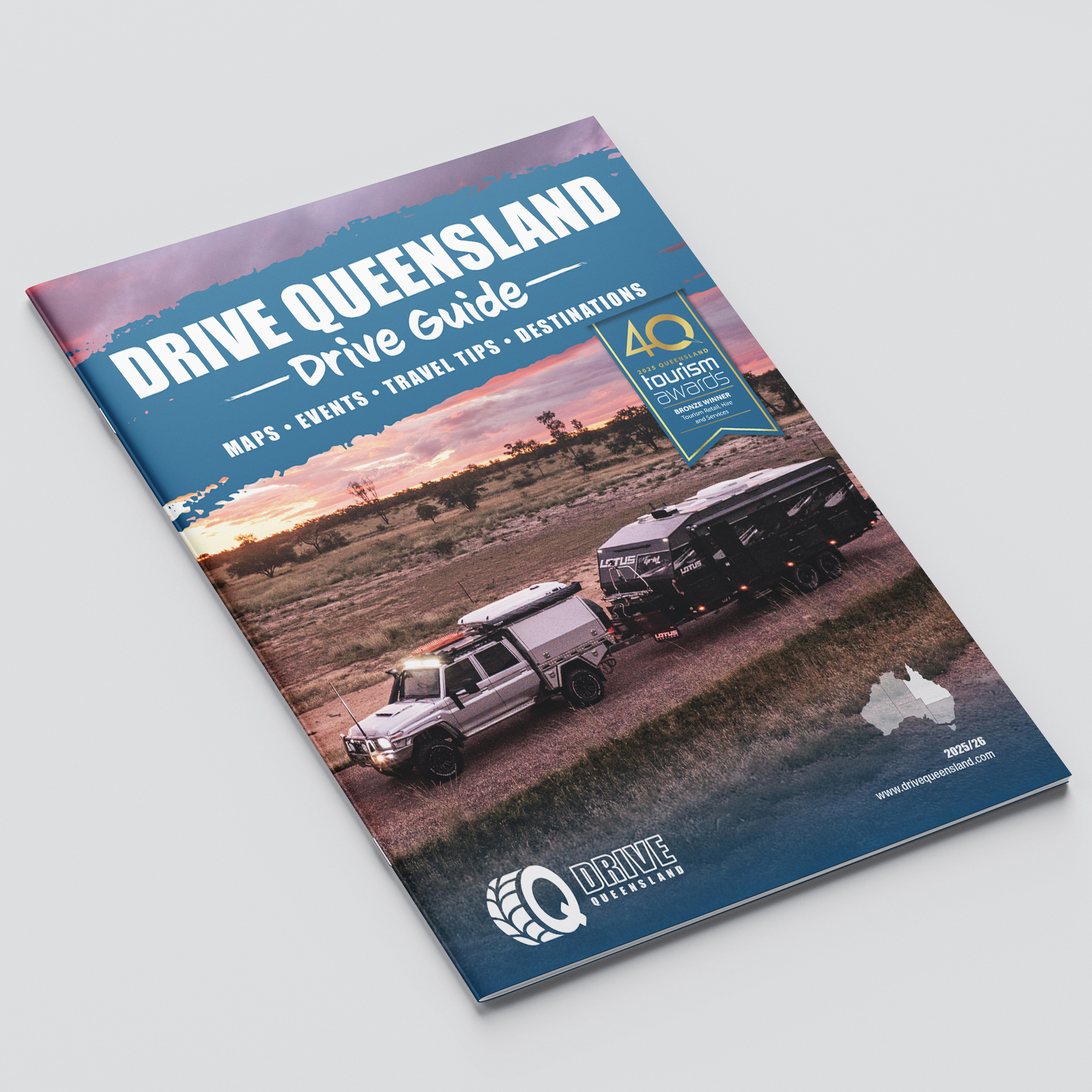A magazine titled "Drive Queensland Drive Guide" featuring a photo of a vehicle towing a caravan at sunset, with text about maps, events, travel tips, and destinations.