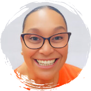 A woman wearing glasses and an orange top smiles at the camera, with her hair pulled back and a white background.